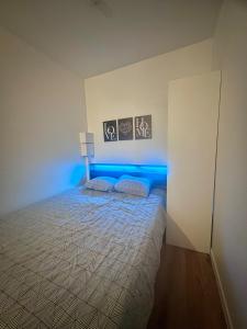 Schlafzimmer mit einem Bett mit blauem Licht in der Unterkunft The Urban Refuge in Champs-Sur-Marne