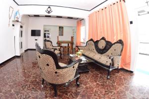 a living room with chairs and a table at Royal Residence Negombo in Negombo