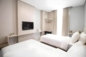 um quarto de hotel com duas camas e uma TV em MIC Residence em Yogyakarta