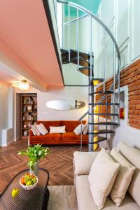 een woonkamer met een trap en een bank bij Copernicus House & Spa in Krakau