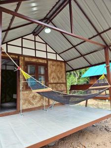 a hammock in front of a house at Phayam Local homestay in Ko Phayam