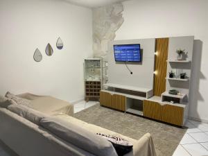 un soggiorno con divano e TV a schermo piatto di Casa com piscina e área kids a Serra