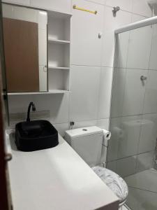 un bagno con un water, un lavandino e uno specchio di Casa com piscina e área kids a Serra Altre 8 foto