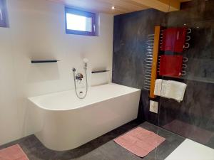 een wit bad in een badkamer met douche bij Haus Kanisfluh in Au im Bregenzerwald