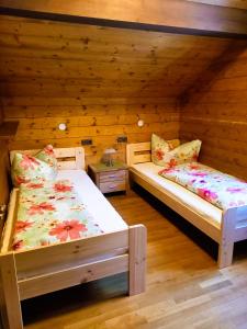 twee bedden in een kamer met houten wanden bij Haus Kanisfluh in Au im Bregenzerwald