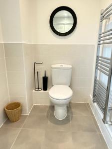 un bagno con un water bianco e uno specchio di Modern 3-Bedroom Home in Bletchley, Milton Keynes a Bletchley