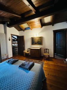 una camera con letto blu in una stanza con soffitti in legno di Agriturismo Ca' di Mazza a Monzuno Altre 98 foto