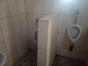 Un baño con dos urinarios y un urinario. en Chirundu - Zambezi River Campsite & Swimming Pool & WiFi, en Chirundu