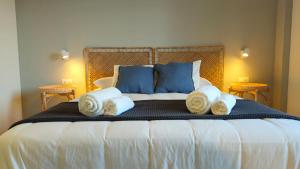 a bed with two pillows and towels on it at Hotel Rural Mirador de Jubrique in Jubrique