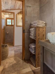a bathroom with a stack of towels on a shelf at Chalet with fireplace and sauna in Meiringen