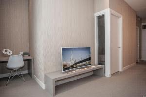 a living room with a tv and a chair at Maurits Apartments & Suites in Rotterdam