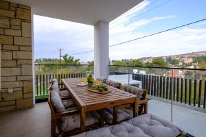 a dining room with a table and chairs on a balcony at Pamboo TerraVine House by Nomads in Statos and Ayios Photios