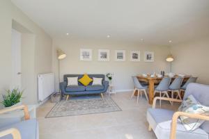 een woonkamer met een blauwe bank en een tafel bij 3 Bed in Wighton oc-1978 in Wighton