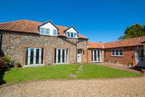 een oud stenen huis met een gazon ervoor bij 3 Bed in Wighton oc-1978 in Wighton