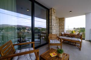 a room with a balcony with tables and chairs at Pamboo TerraVine House by Nomads in Statos and Ayios Photios