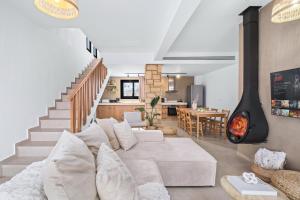 a living room with a white couch and a fire place at Pamboo TerraVine House by Nomads in Statos and Ayios Photios