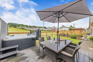 a patio with a table with an umbrella and a hot tub at 2 Bed in Bala oc-82212 in Bala