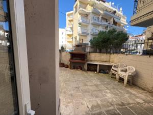 a balcony with two chairs and a piano in front of a building at KTELI Sleep & Chill Apartment in Komotini
