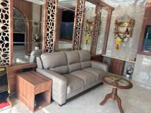ein Wohnzimmer mit Sofa und Tisch in der Unterkunft Hotel Imperial Suites in Navi Mumbai + 16 Fotos