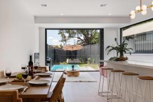 een open keuken en eetkamer met een tafel en stoelen bij Poolside Luxury Villa - Solar Pool Beach 3min in Mornington