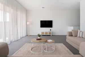 a living room with a couch and a table at Poolside Luxury Villa - Solar Pool Beach 3min in Mornington