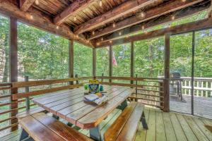ein hölzerner Picknicktisch auf einer abgeschirmten Veranda mit Fenstern in der Unterkunft A Refined Retreat Perfect for Couples or Families in Westcolang Park