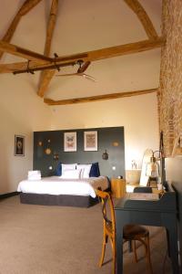 Un dormitorio con una cama grande y un escritorio. en Les Chambres du parc, en Monnières 51 fotos más