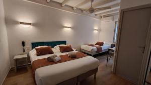 オランジュにあるHôtel L'Herbier d'Orangeの部屋にベッドが2つある寝室
