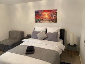 Un dormitorio con una cama grande y una silla. en Apartmani Teša, en Tešanj