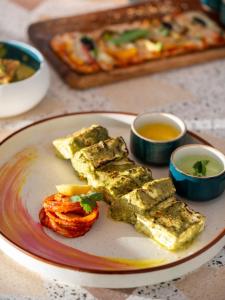 une assiette de nourriture sur une table avec de la pizza et des sauces. dans l'établissement Bun and Bunks, à Udaipur