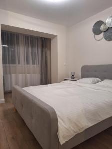 een groot wit bed in een slaapkamer met een raam bij Mateo rezidence in Bistriţa