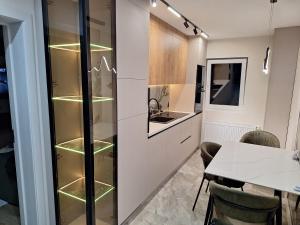 una cucina con una dispensa in vetro e un tavolo di Mateo rezidence a Bistriţa