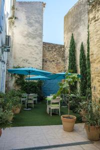オランジュにあるHôtel L'Herbier d'Orangeの中庭のパティオ(テーブル、パラソル付)