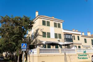 een groot wit gebouw met een hek ervoor bij Zuri's Loft Islantilla Golf in Isla Cristina