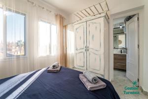 een slaapkamer met een bed met twee handdoeken erop bij Zuri's Loft Islantilla Golf in Isla Cristina +19 foto's