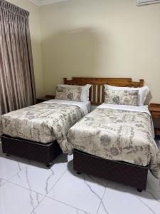 twee bedden naast elkaar in een slaapkamer bij Pink Rock Villa in Durban