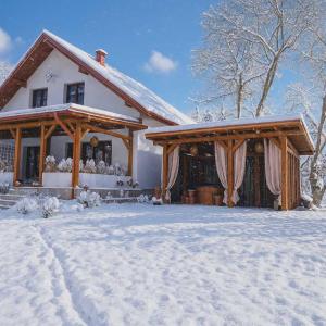 ein Haus mit Schnee auf dem Boden davor in der Unterkunft Mazurska Ostoja Wiartel in Wiartel + 20 Fotos