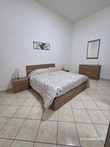 een slaapkamer met een bed, 2 dressoires en een spiegel bij B&B Domus Morfeo 2 in Casagiove