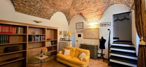a living room with a yellow chair and a fireplace at Casa del Comandante- Bluchalet in Cervo