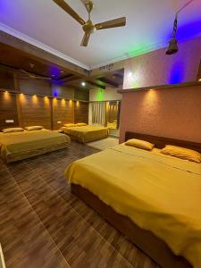 een slaapkamer met twee bedden en een plafondventilator bij Palmstone Retreat in Gādigarpālya