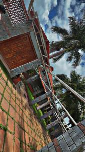 een trap naar een gebouw met een palmboom bij Palmstone Retreat in Gādigarpālya +17 foto's