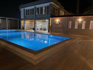 een zwembad voor een gebouw 's nachts bij Palmstone Retreat in Gādigarpālya