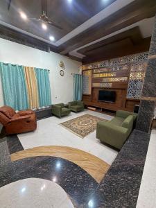 een woonkamer met meubilair en een flatscreen-tv bij Palmstone Retreat in Gādigarpālya