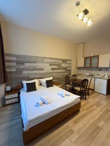 PM Services Flora Apartments في بوروفتس: غرفة نوم مع سرير كبير ومطبخ