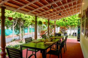 a dining room with a green table and chairs at Eco Serenity Pet-friendly Charming 2-BHK Villa With Lush Garden, Gazebo, Private Pool & Open Dining Close to Nandi Hills in Oddarahalli