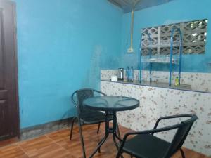 een tafel en stoelen in een kamer met een blauwe muur bij Future home Maetang in Sop Poeng