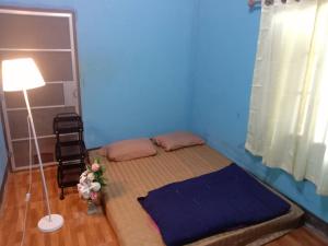 een bed in een kamer met een blauwe muur bij Future home Maetang in Sop Poeng