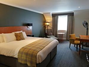 una habitación de hotel con una cama y un escritorio en Best Western Plus Angel Hotel, en Chippenham