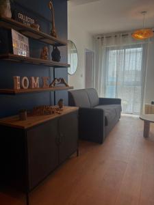 een woonkamer met een bank en een tafel bij Charmant appartement in Vitré