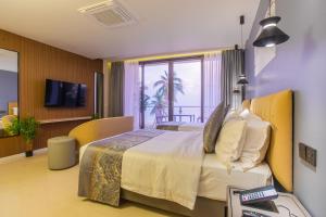 a hotel room with a bed and a television at Lonuhiri at Dhigurah in Dhigurah